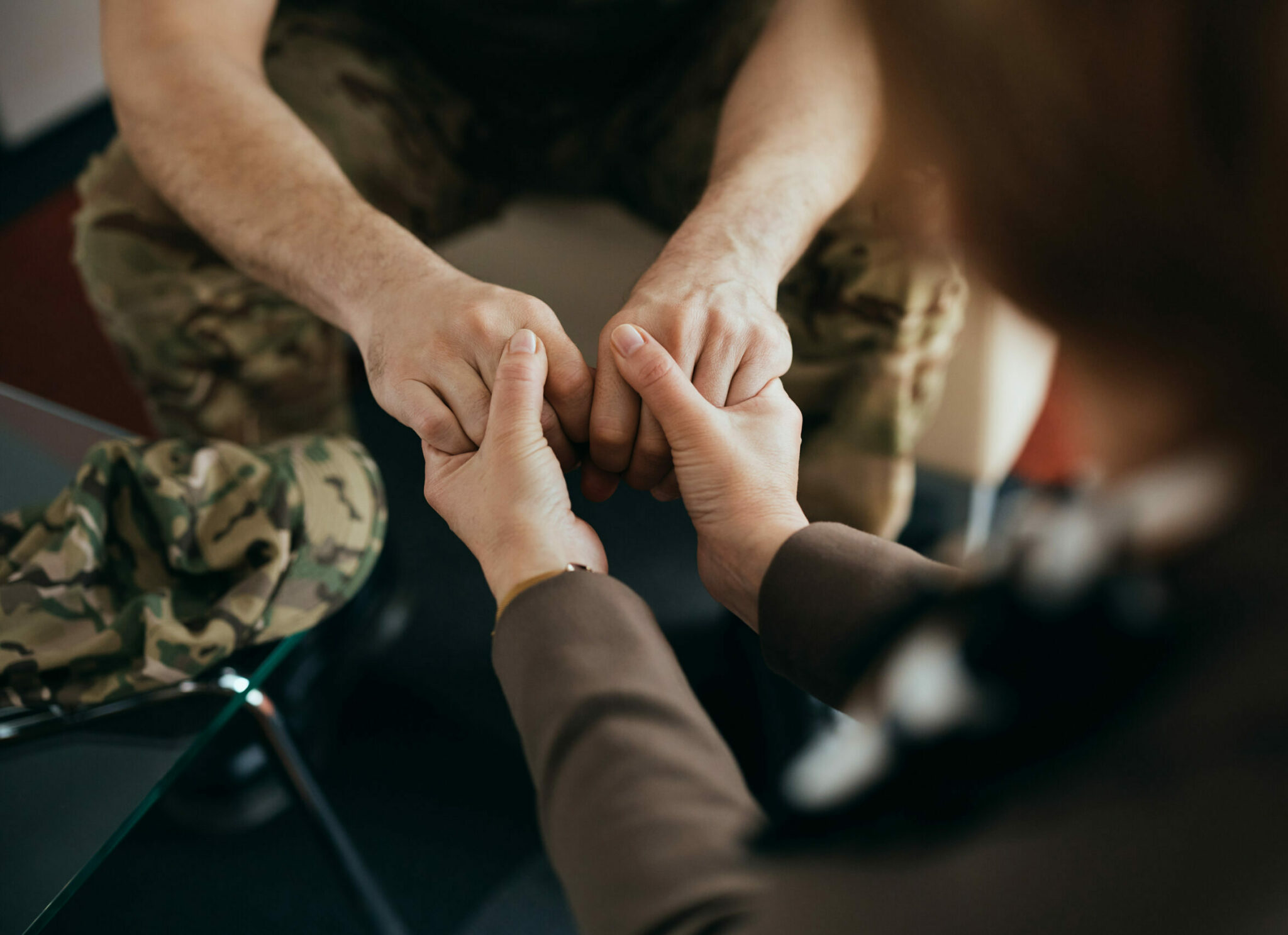 Two people holding hands while sitting on a couch.