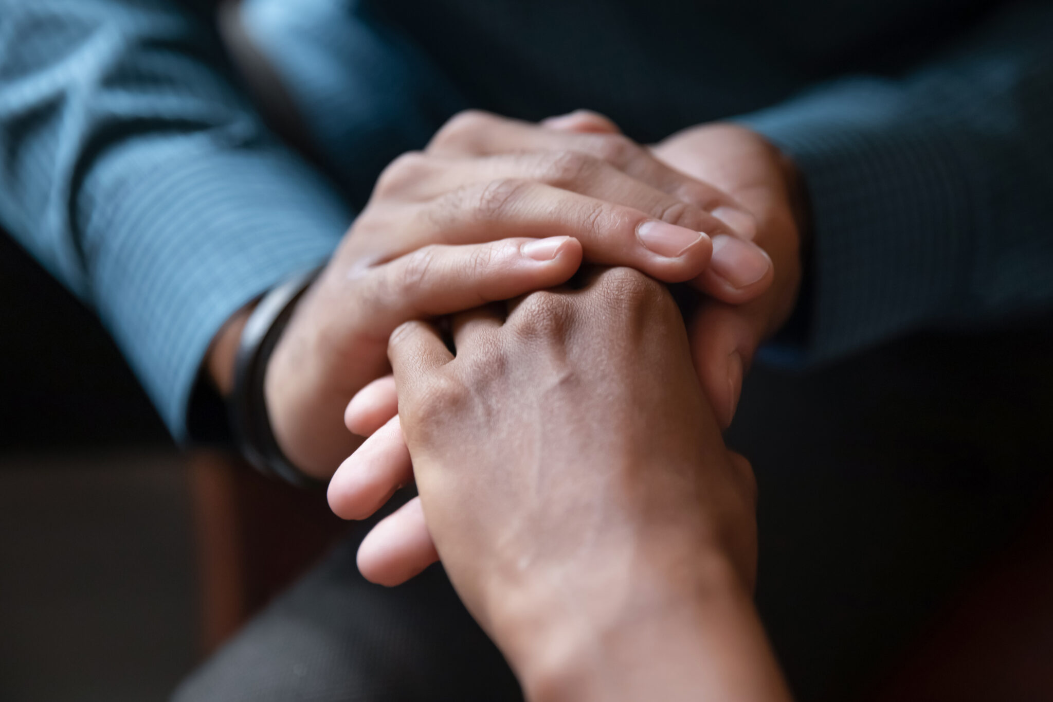 Two people holding hands in a group.