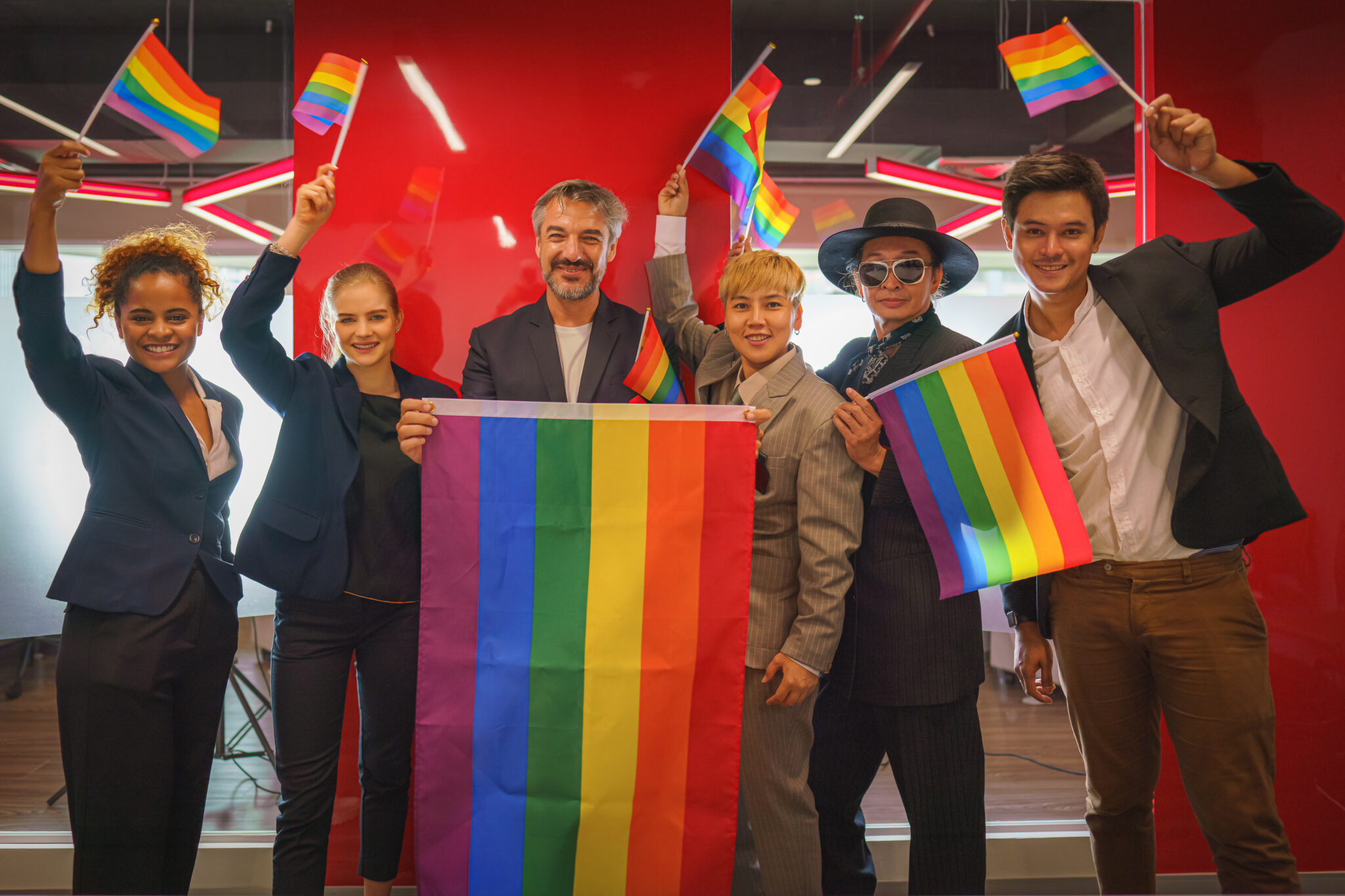 A group of people holding flags and smiling.