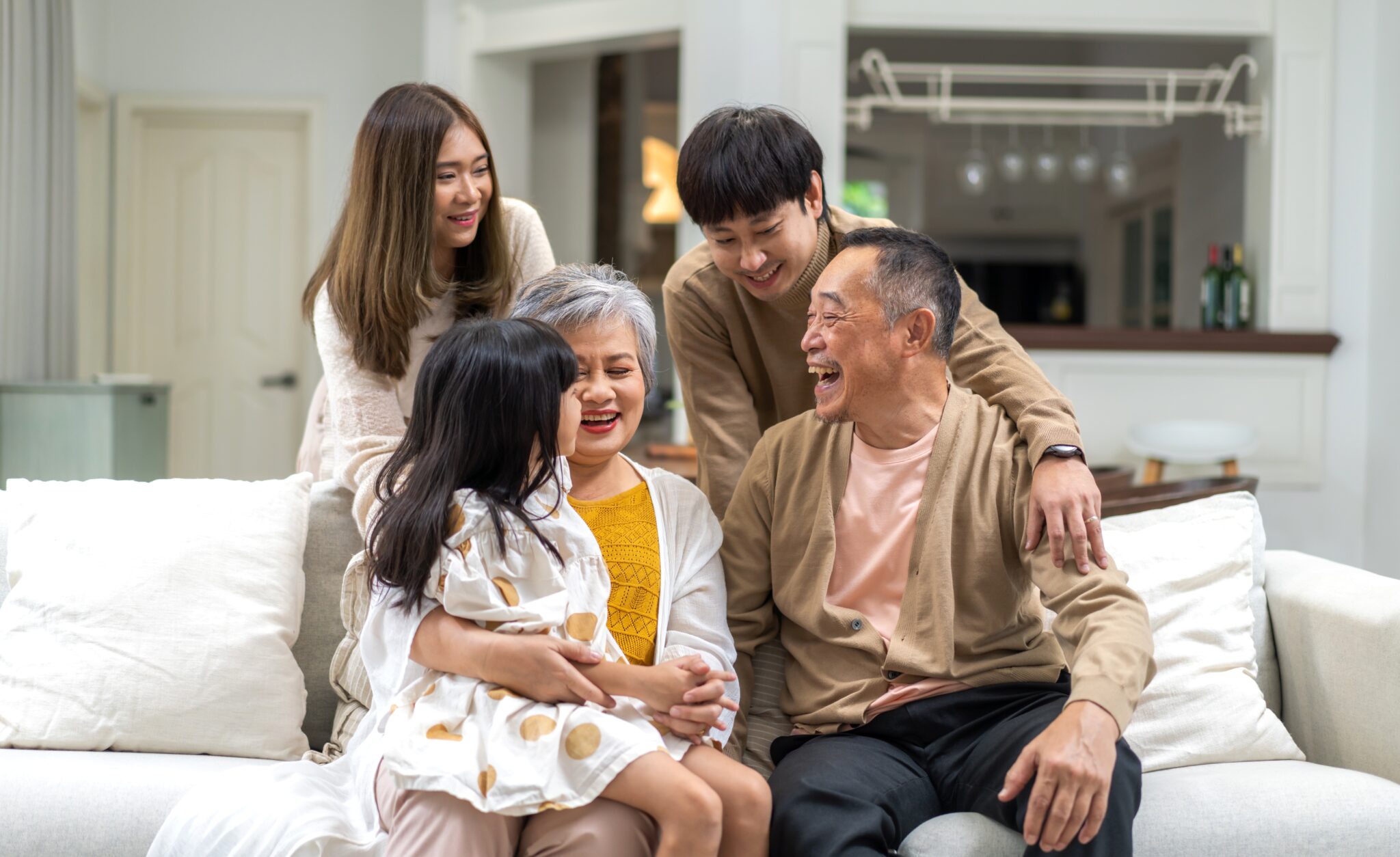 A family sitting on the couch laughing together