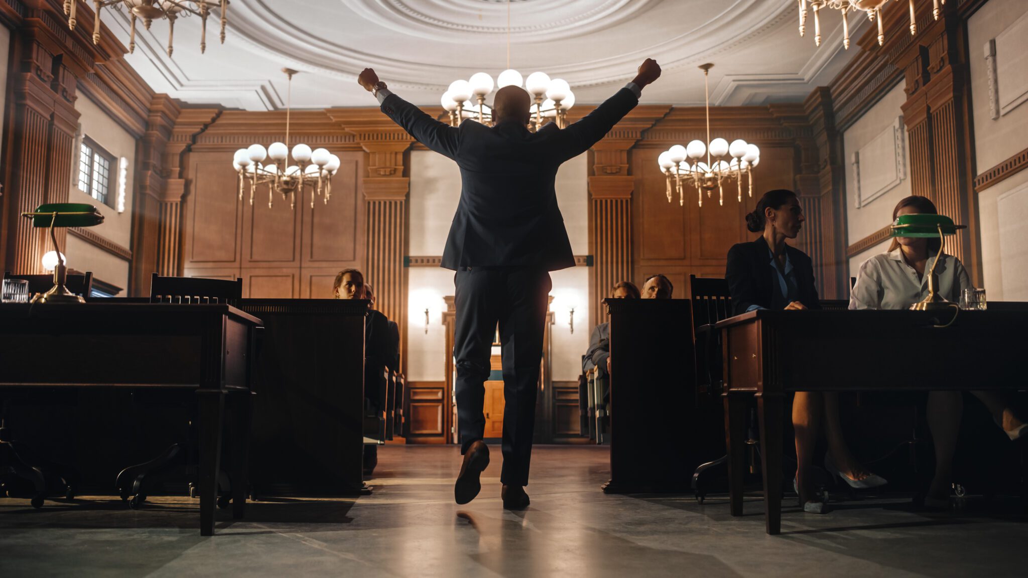 A man in suit and tie jumping up into the air.