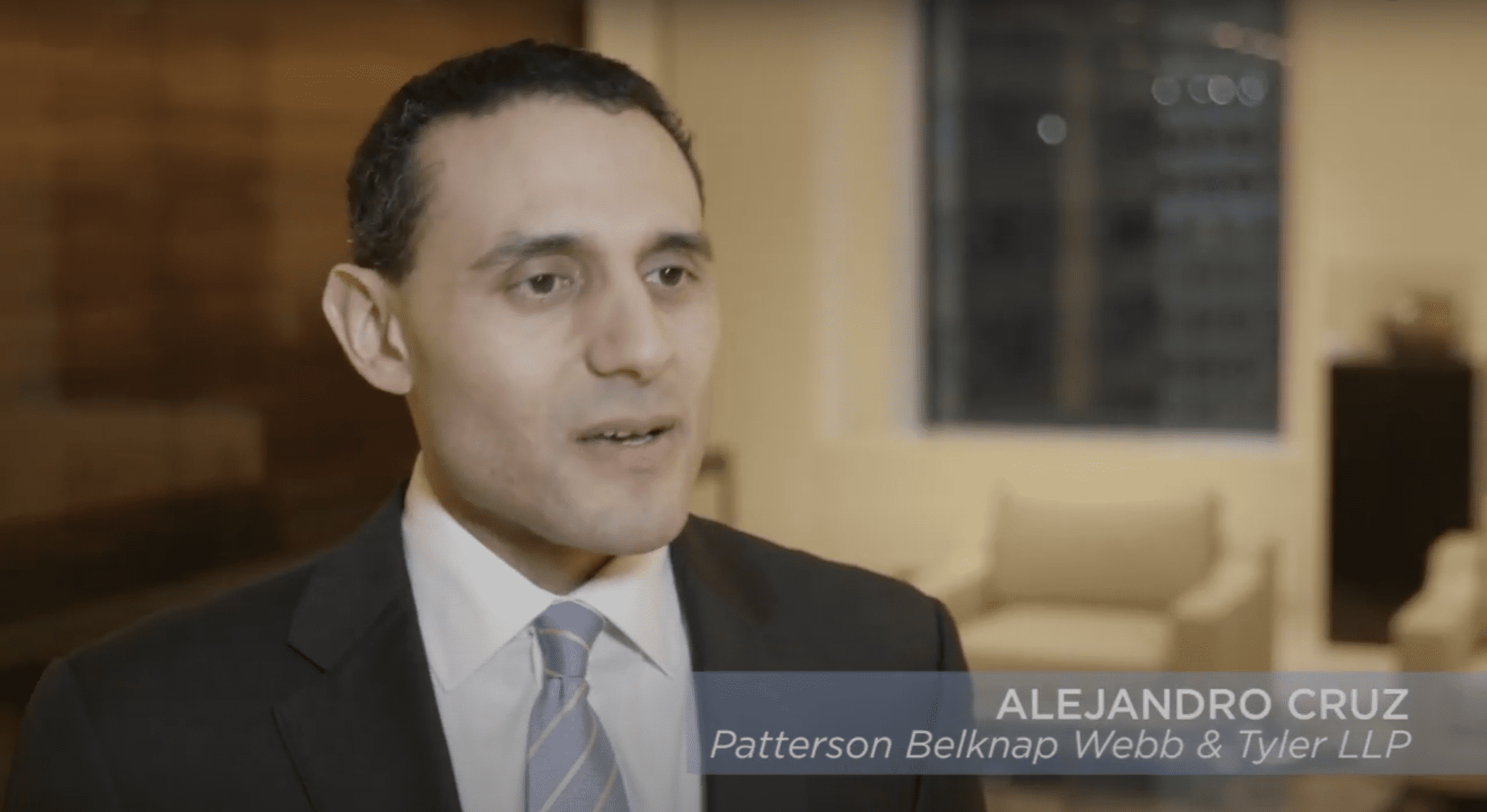 A man in suit and tie talking to the camera.